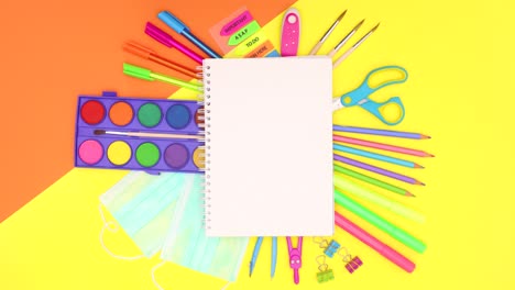 school stationery move under open notebook. back to school covid-19 stop motion