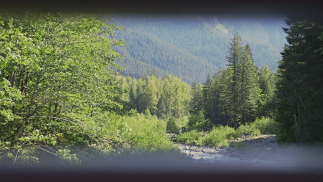 Wide Shot dolly out to frame within frame of a river and mountain landscape