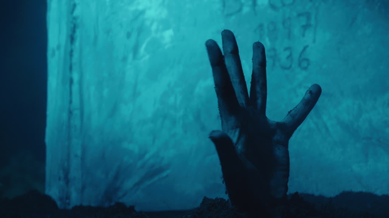 mano saliendo de la tumba, lápida en el fondo, concepto de muertos vivientes, atmósfera de terror a la luz de la luna