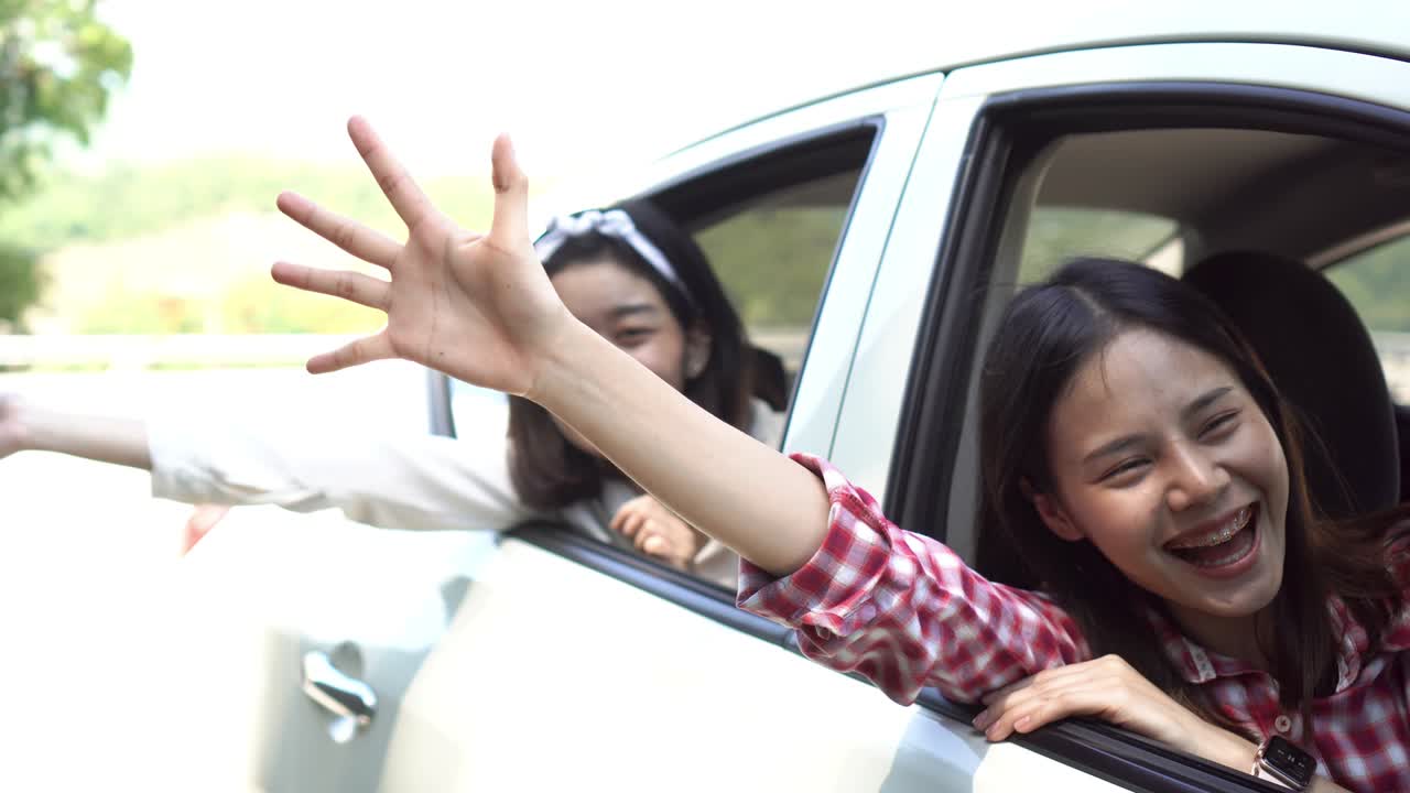 휴가 시간과 여행, 세 명의 아름다운 젊은 여성은 편안한 휴가를 위해 함께 즐겁게 여행합니다. 그리고 차에서 웃음. 지도에 의해 방향을 찾습니다.