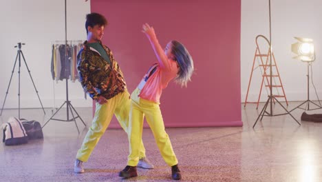 Portrait-of-happy-diverse-male-and-female-dancers-dancing-together-in-dance-studio,-slow-motion