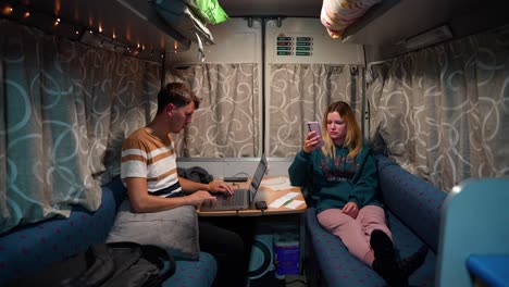 couple of digital nomads working remotely inside the caravan