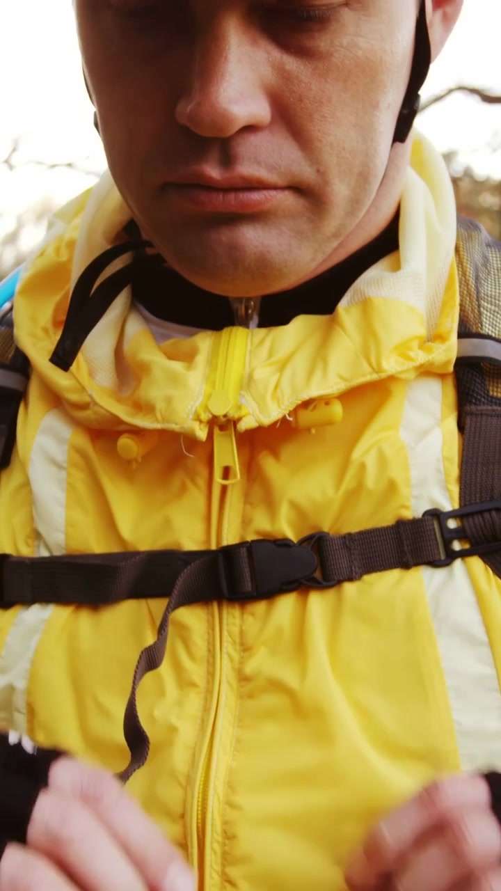 Vídeo vertical: Ciclista apertando a alça, com navegação sobrepondo a jaqueta, segurando o guidão para pedalar.