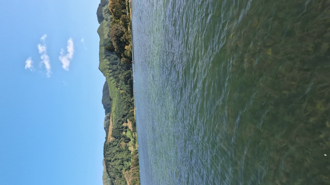 vertical of young male traveller paddling in ake, Sete Cedades, Azores island