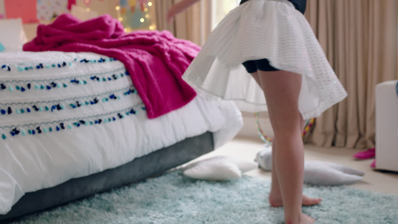 행복한 십대 소녀가 침실에서 춤을 추고 발레 투투를 입고 집에서 춤 동작을 연습하는 재미를 느끼고 있습니다.