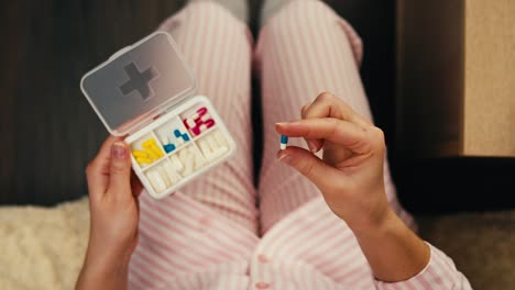 woman taking medicine in pajamas