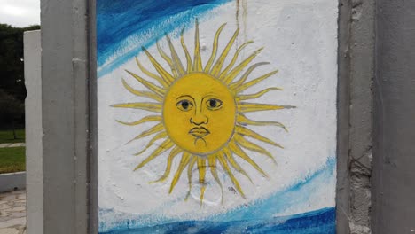 closeup shot at argentine flag blue white with golden sun painted in a wall