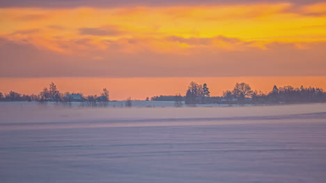 winter rural time lapse moving clouds in golden sky in foggy morning, rural latvia