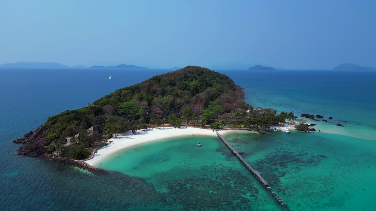Koh Kham Island with crystal clear turquoise water, white sand beaches and lush tropical vegetation, a popular tourist destination in Thailand. Beautiful aerial view flight panorama overview drone