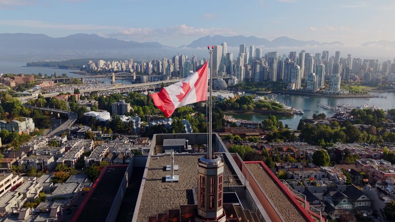 Skyline del centro di Vancouver catturato con la bandiera canadese che sventola nella Columbia Britannica, Canada - ripresa con drone.