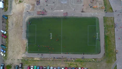 vista aérea sobre un campo de fútbol, equipos jugando fútbol, en un barrio pobre y tugurio de kiev, día nublado, en kiev, ucrania - de arriba hacia abajo, tiro de drones
