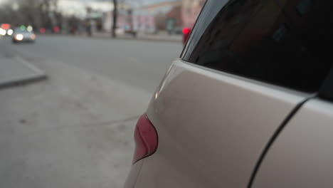 close-up view of a parked car with its rear in focus, while other cars are seen approaching from behind