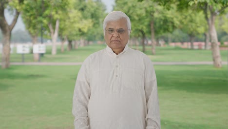 indian old man looking at the camera in park