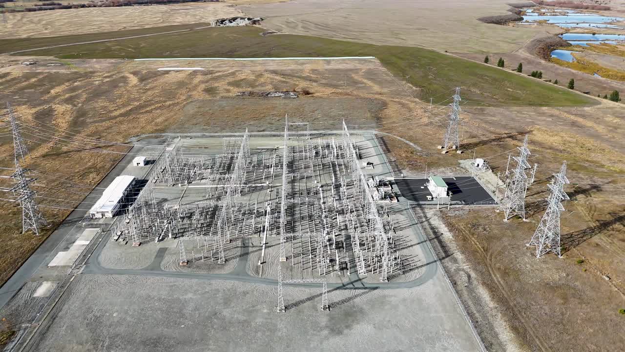 Drone footage captures a high-voltage power substation surrounded by autumn landscapes at Lake Tekapo, New Zealand