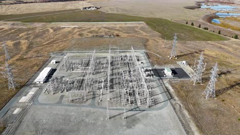 drone footage captures a high-voltage power substation surrounded by autumn landscapes at lake tekapo, new zealand