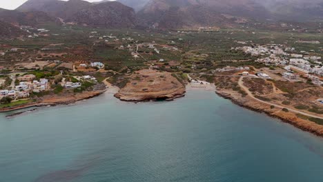 aerial - coastal area with two mini beaches and mountain backdrop in crete greece