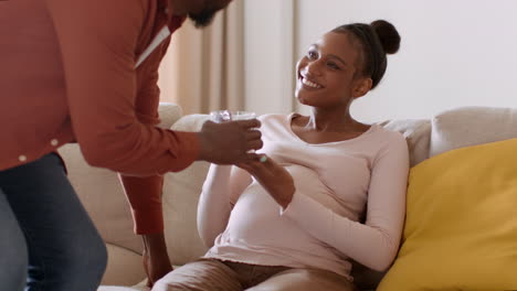 pregnant woman receiving water from partner
