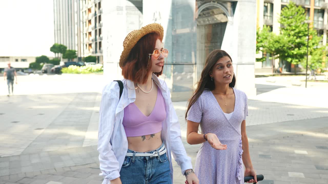 두 여자 친구 가 도시 거리 에서 고 대화 하고 있다