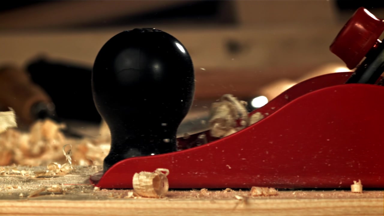Trucioli di legno che volano da una pialla a mano al rallentatore