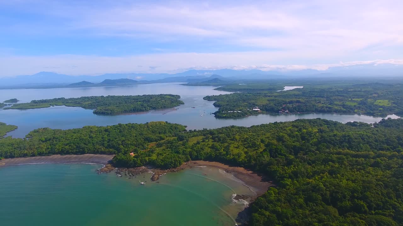 elevándose por encima de un hermoso paisaje acuático con islas y tierra verde que se unen en las costas subdesarrolladas de panamá.