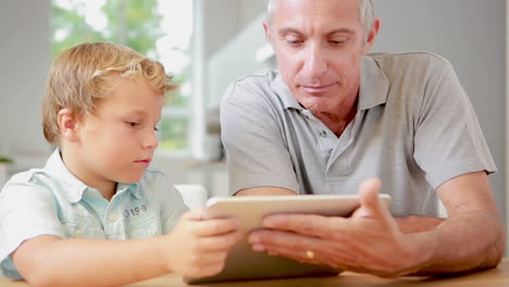 child using tablet with his grandfather