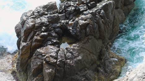 blue sea waves makes white foam and crashing on the big rock