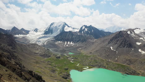 drone volando sobre un hombre parado en la cima de una montaña sobre el lago ala-kol en kirguistán