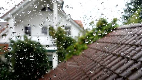 rain drops on window glass with view to the neighbor house