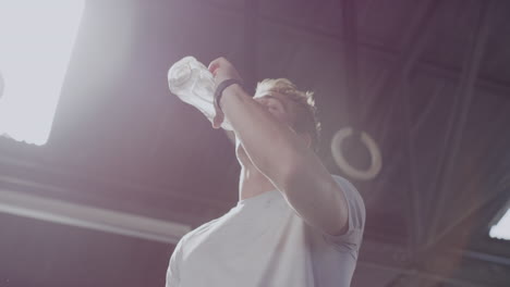 active young man drinking water during a break