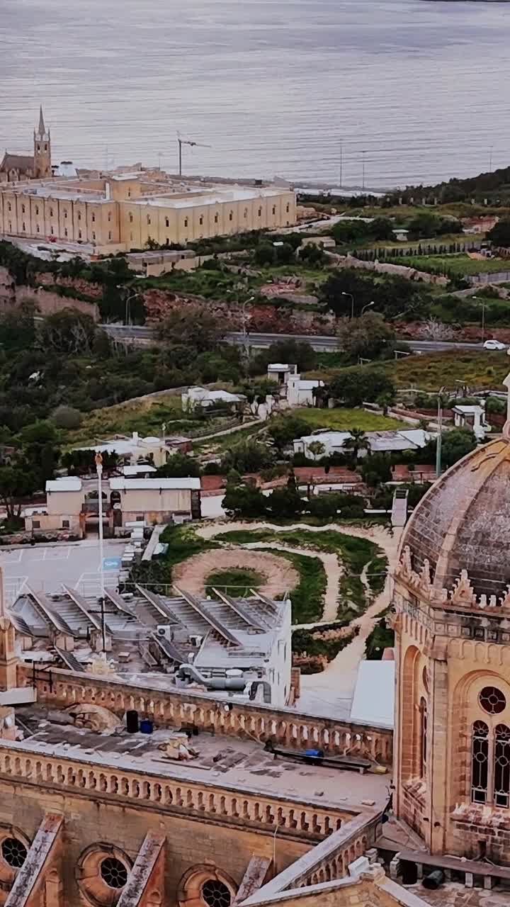 Vista di una chiesa a Malta con mare e città sullo sfondo durante il giorno
