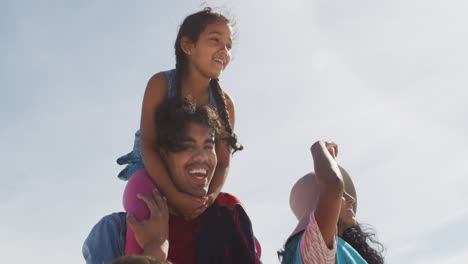 Close-up-of-happy-hispanic-mother,-father,-son-and-daughter-walking-on-beach