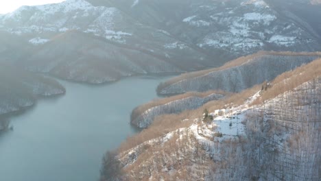 aerial view of a lake surrounded by the snow