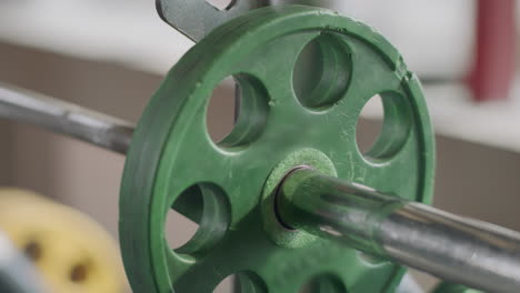 Closeup-man-hands-handing-barbell-pancake-for-training-in-gym-club.