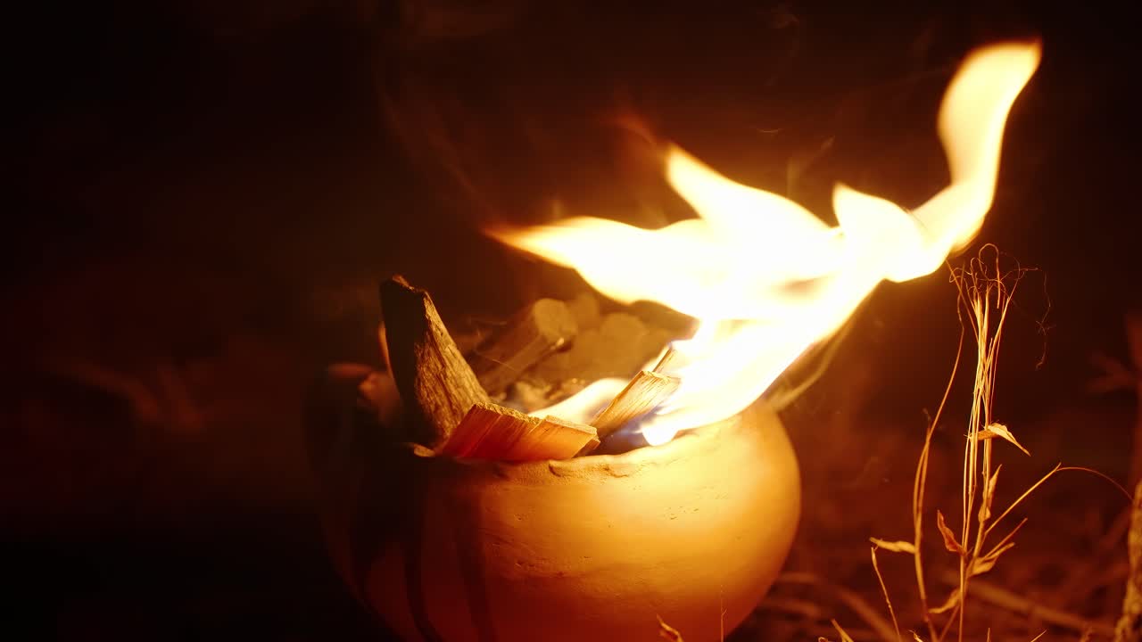 A chama sagrada queima dentro de um vaso de barro durante uma cerimônia maia