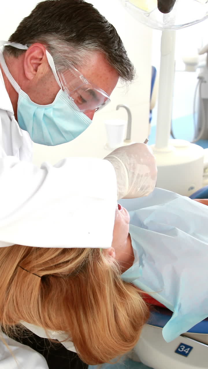 Dentista examinando los dientes de una mujer.