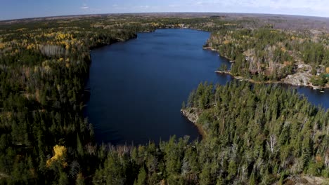 aerial dolly forward of blue lakes nestled in a boreal forest in the idyllic canadian shield