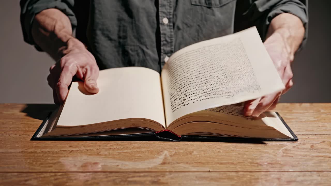 persona leyendo un gran libro abierto en una mesa de madera