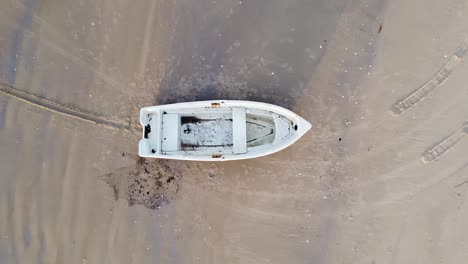 aerial view of baltic sea coastline at bernati beach in latvia, flying upwards over white sand beach and fisherman boat, wide angle establishing drone shot