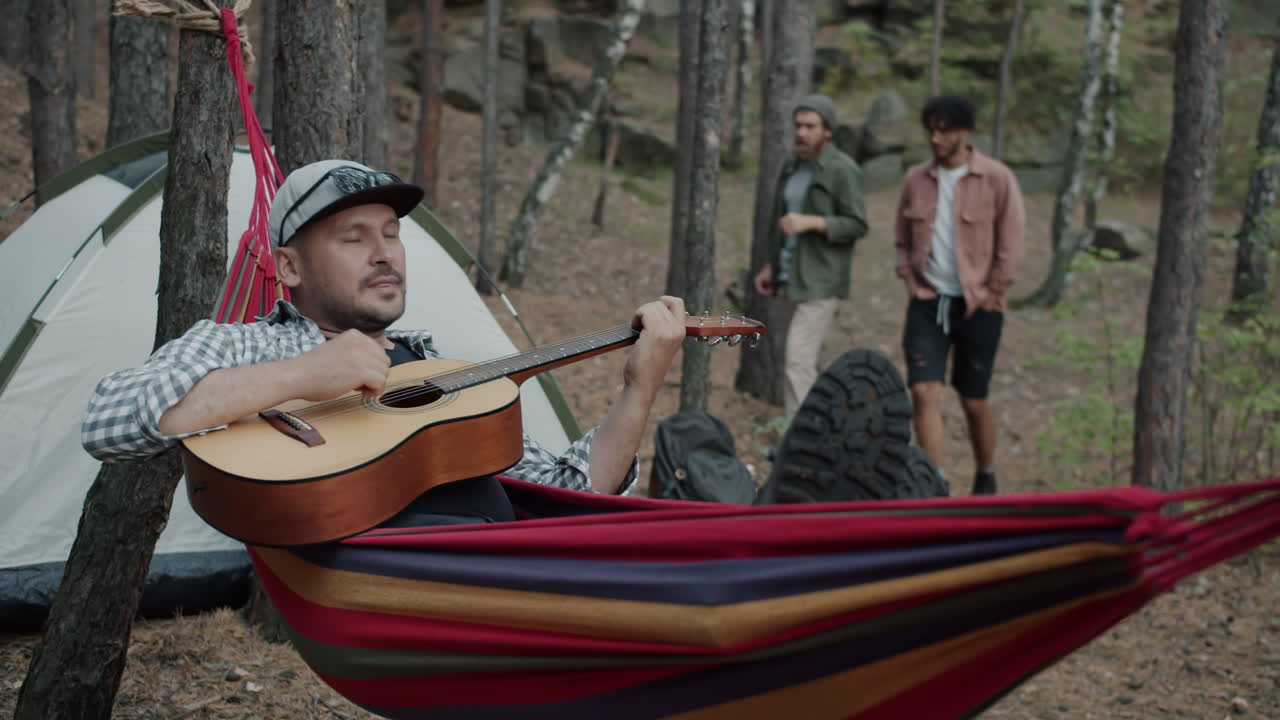 Friends Camping and Playing Guitar