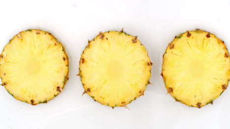 en cámara lenta salpicaduras de agua verter agua sobre una hermosa fruta jugosa con muchos anuncios en un fondo blanco. vegetariano y fructorianos.