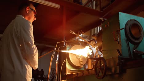 vista lateral de un trabajador caucásico que crea vidrio en una fábrica de vidrio 4k