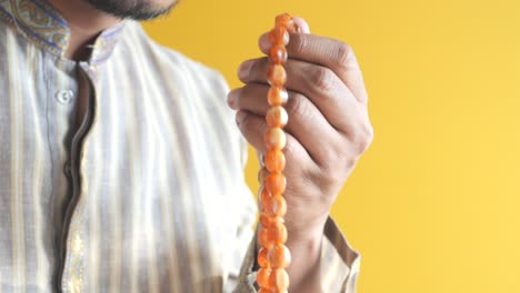 close-up of a man's hands holding prayer beads