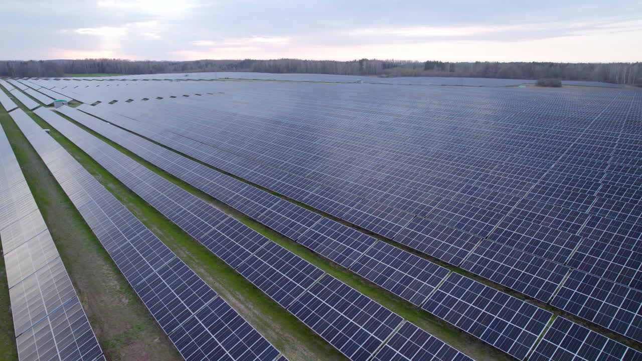 воздушный снимок большой фотоэлектрической солнечной панели, установленной в зеленом поле в сельской местности в облачный день