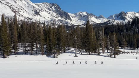 Esquiadores-De-Fondo-En-Senderos-Nevados-Con-Fondo-De-Montaña