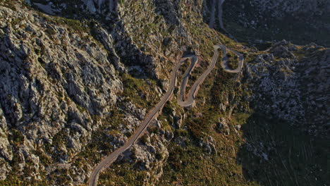 aerial view over winding road coll dels reis in majorca, spain - drone shot