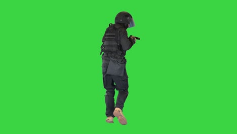 armed police officer aiming and shooting with a pistol while walking on a green screen, chroma key