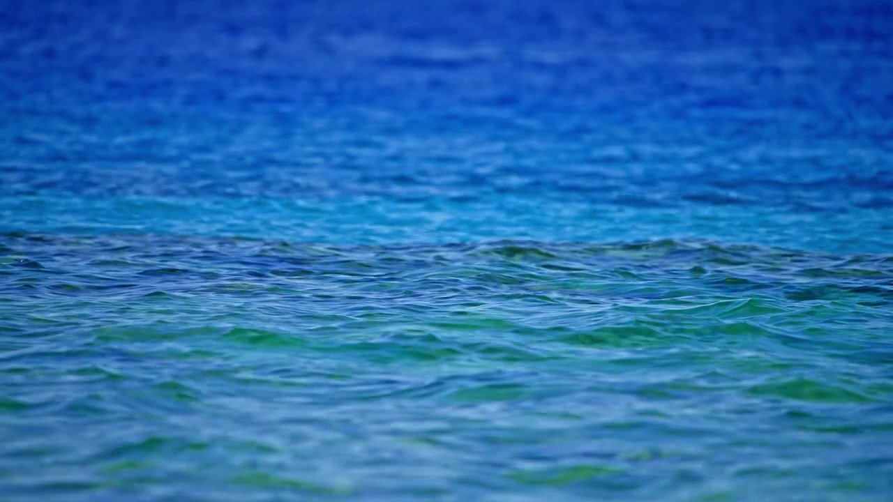 Superficie tranquila de agua oceánica azul y verde con oleaje suave