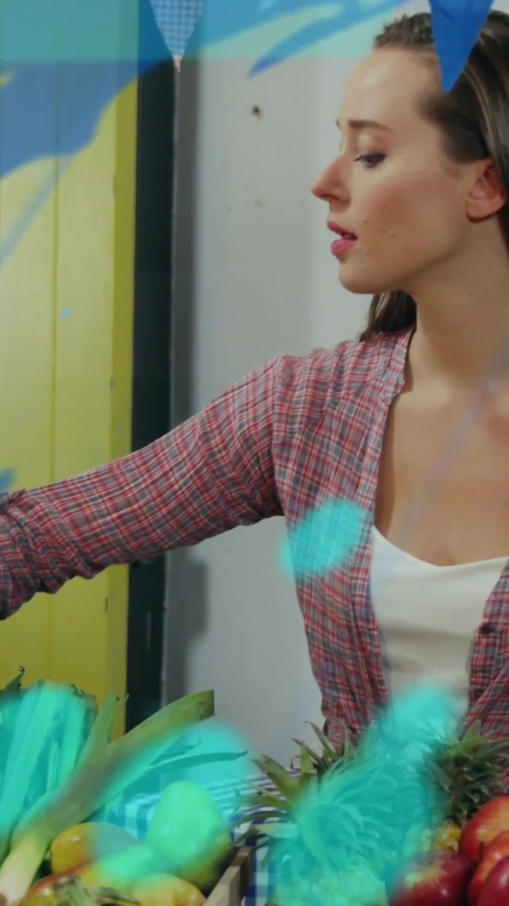 Video verticale: Un venditore tocca una mela, selezionando frutta in vendita mentre un HUD color verde acqua si sposta attraverso il mercato.