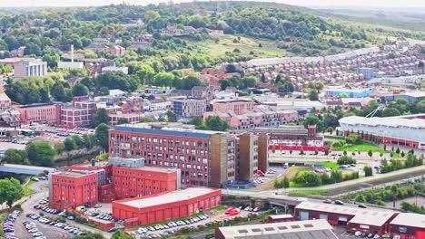 edificio rojo desgastado frente a casas urbanas en expansión en la ladera de la colina en susnet