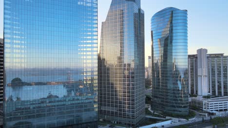 aerial dolly left of window glass skyscrapers reflecting puerto madero docks at golden hour, buenos aires